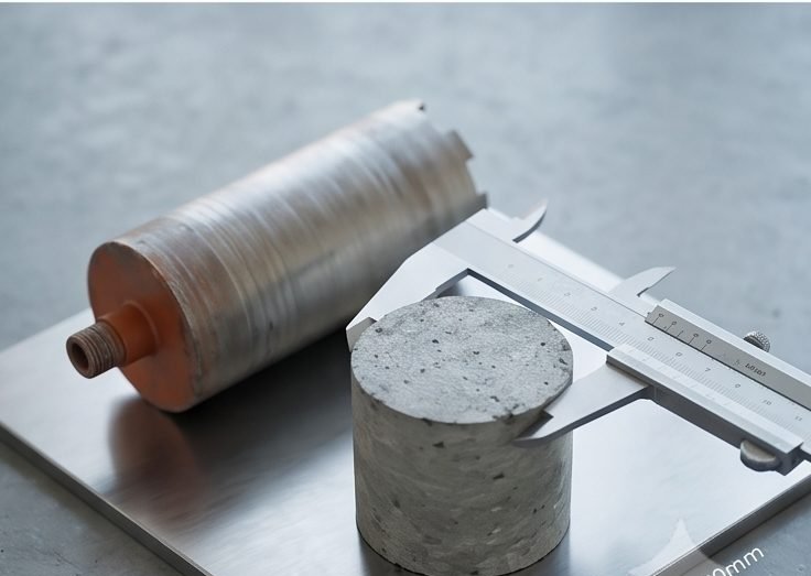 Extracted concrete core sample measured with calipers