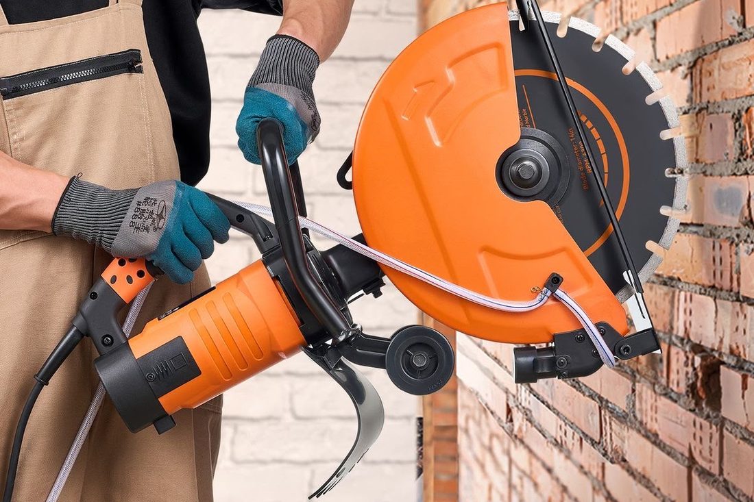 Diamond blade cut-off saw held against a brick wall